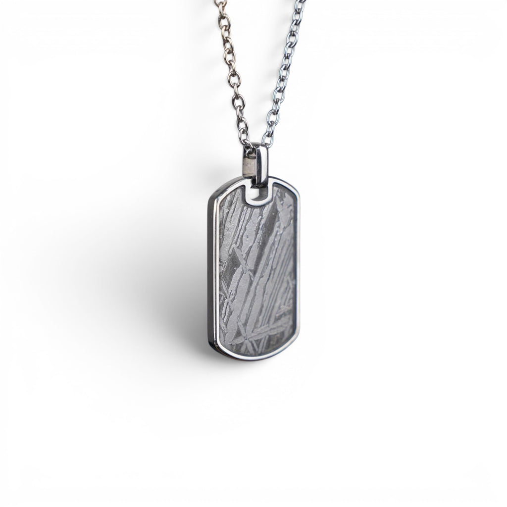 The Field Tag — angled view showing the titanium-grade steel frame and polished edges.