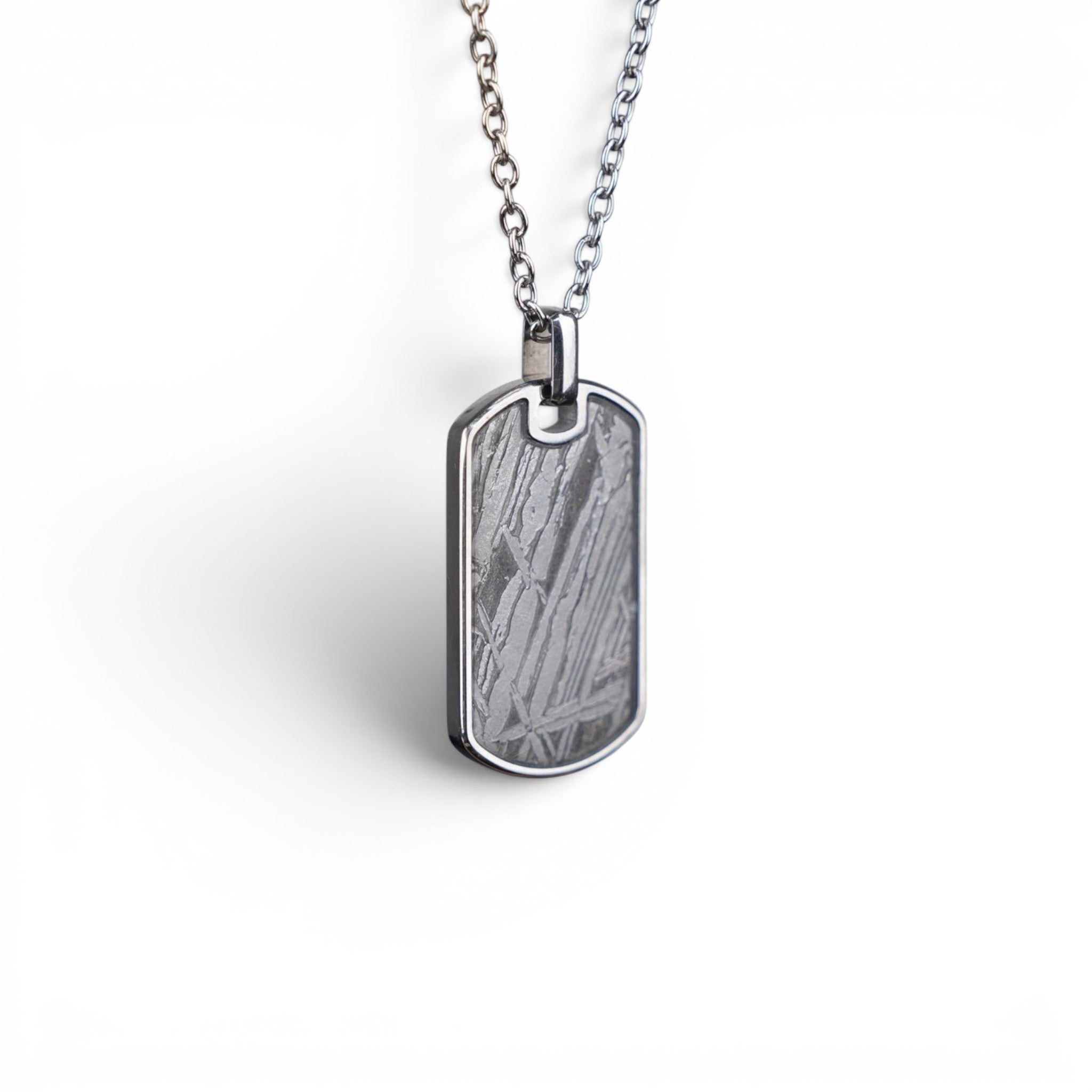 The Field Tag — angled view showing the titanium-grade steel frame and polished edges.
