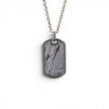 The Field Tag — front view of the dog tag pendant on dark background.