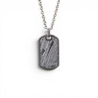 The Field Tag — front view of the dog tag pendant on dark background.