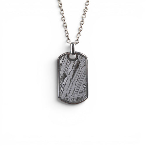 The Field Tag — front view of the dog tag pendant on dark background.
