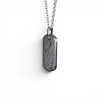 The Field Tag — meteorite dog tag worn on cable chain at the chest, men's heritage jewellery.