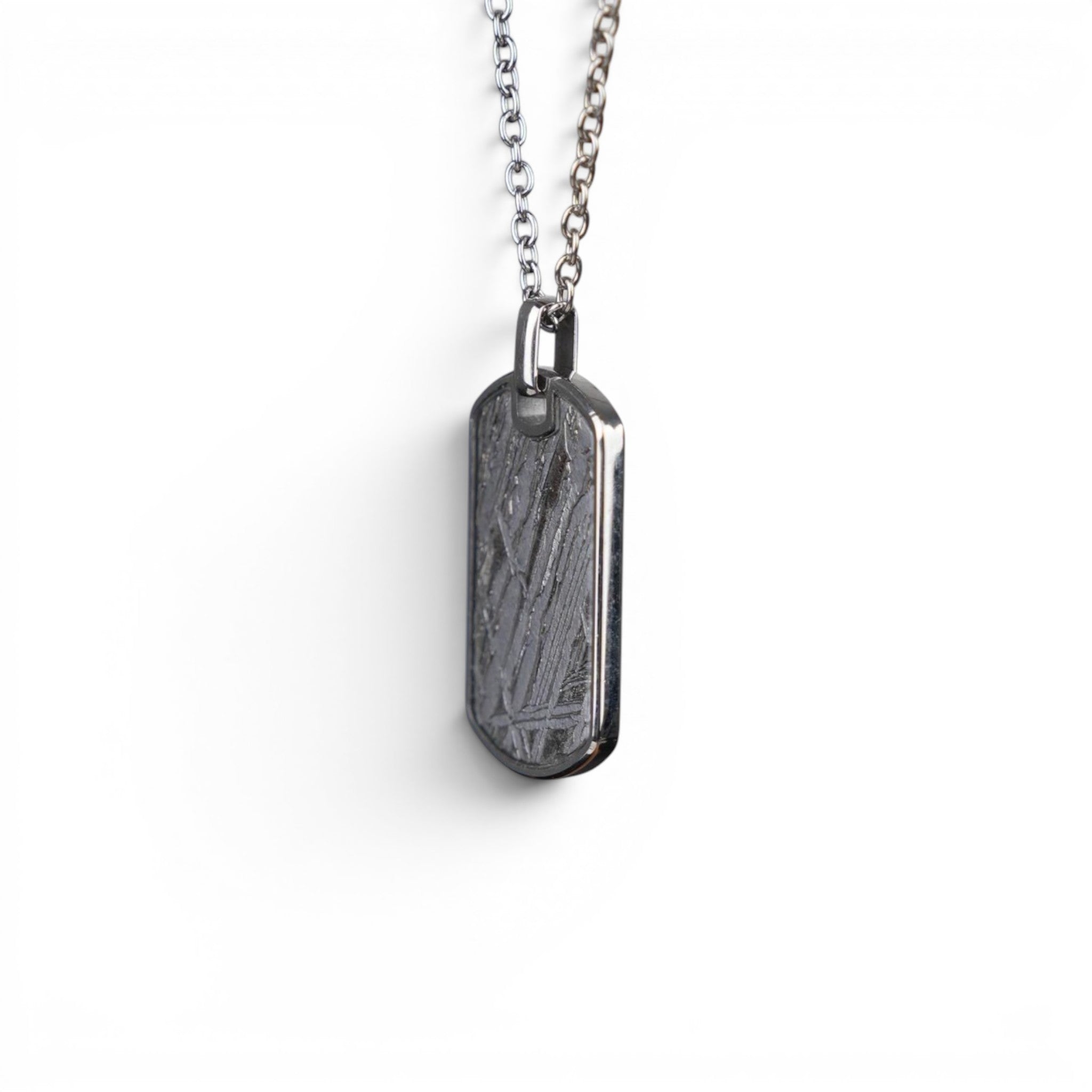 The Field Tag — meteorite dog tag worn on cable chain at the chest, men's heritage jewellery.