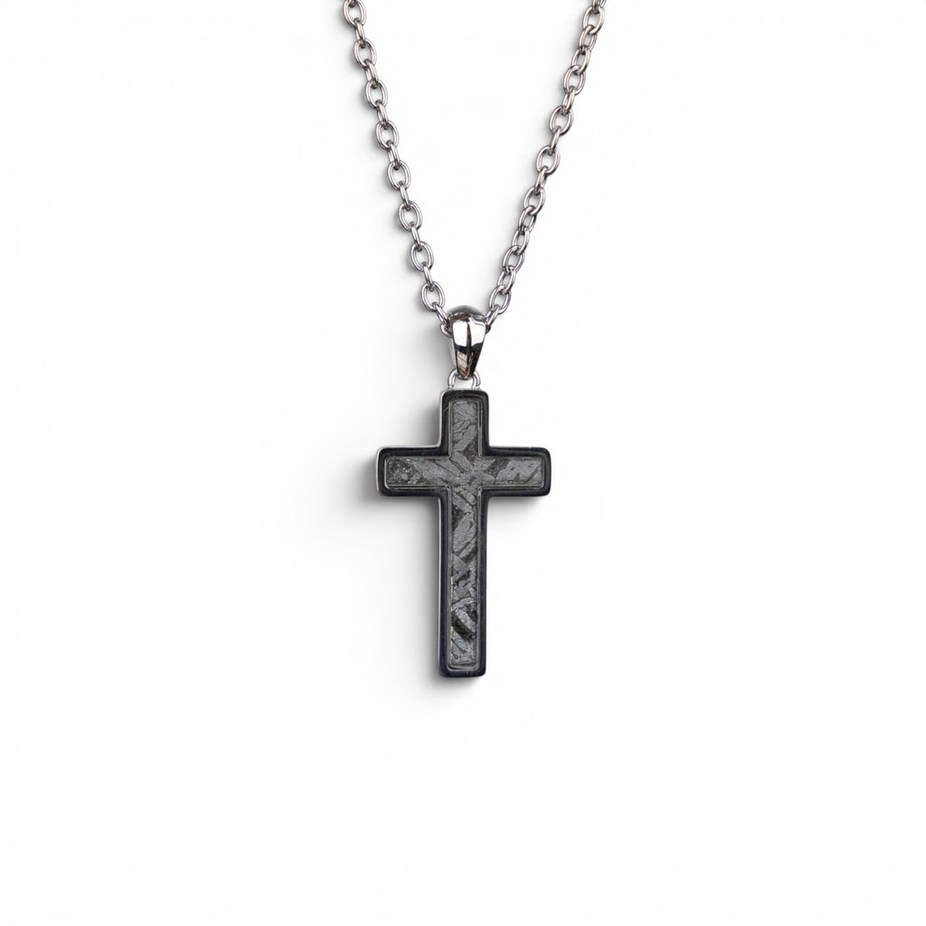 The Cross — angled view of the cross pendant showing depth and the polished titanium-grade steel frame.