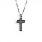 The Cross — angled view of the cross pendant showing depth and the polished titanium-grade steel frame.