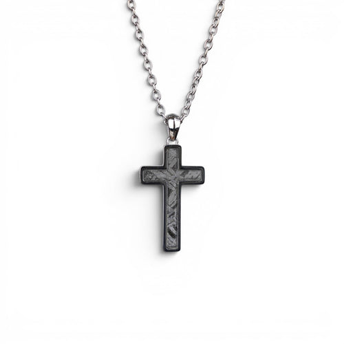 The Cross — angled view of the cross pendant showing depth and the polished titanium-grade steel frame.